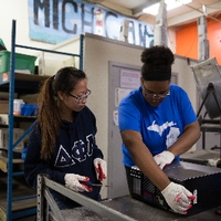 Volunteer students take apart a computer